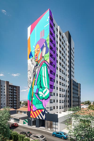 Fachada lateral de edificio com grande mural de arte urbana colorido pintado na empena